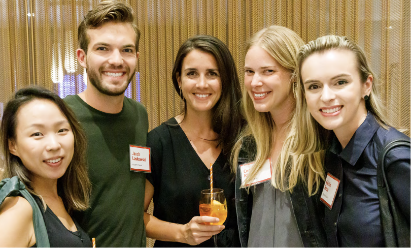 A group of people smiling and posing together at a social or networking event. A group of people smiling and posing together at a social or networking event.
