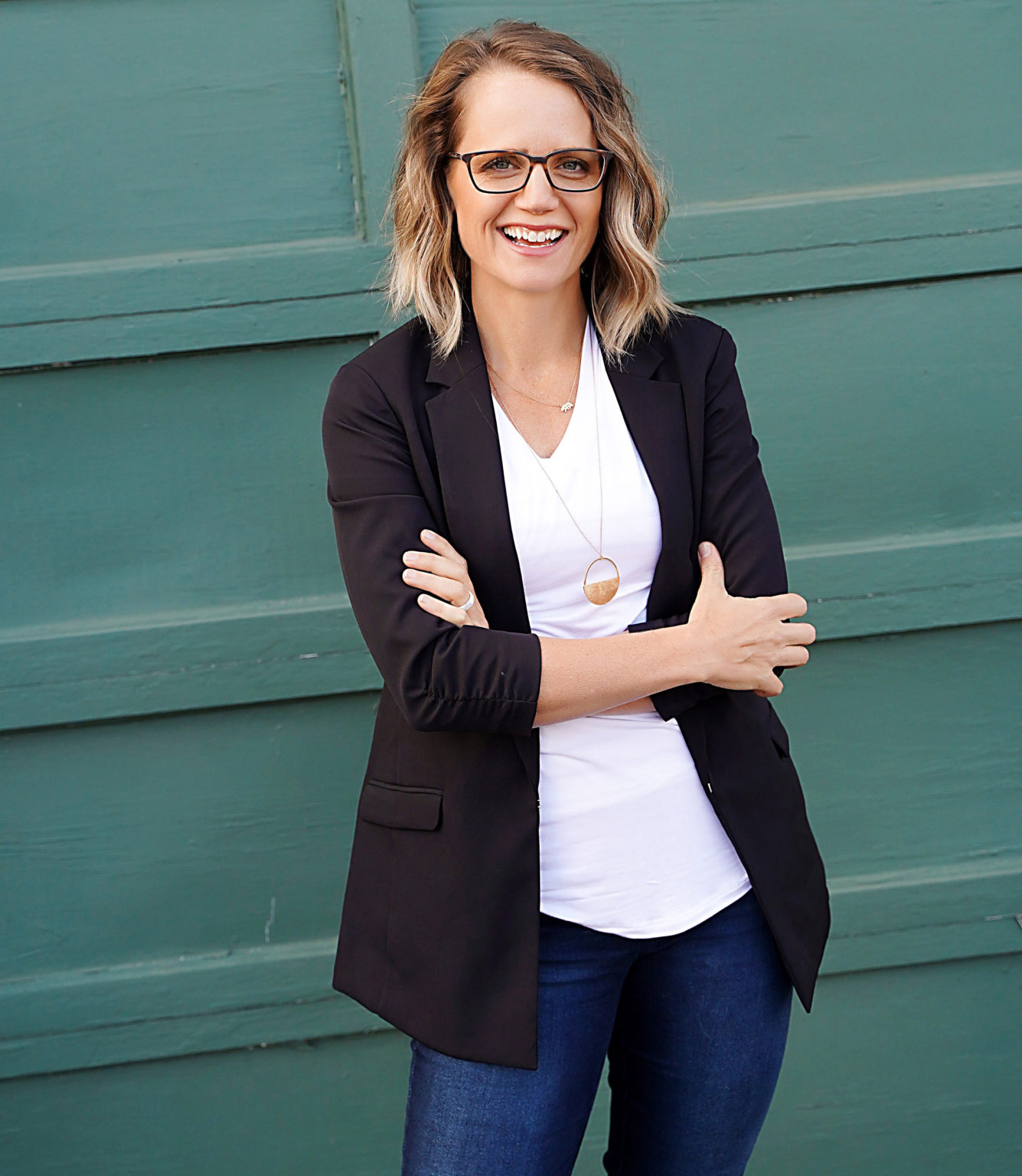 A photo of Amanda Schneider, standing against a green background. A photo of Amanda Schneider, standing against a green background.