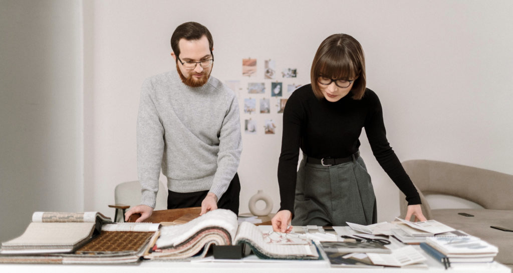 Dealer designers look over project materials in a commercial interior design office